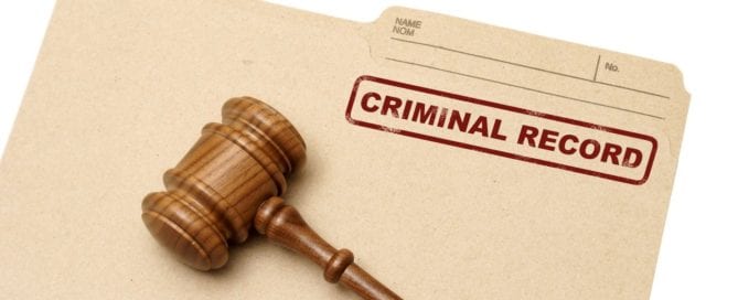 Gavel resting on a criminal record document.